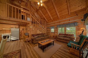 A spacious log cabin interior with a kitchen, dining area, and living room. - All By Grace Cabin Rental (Wears Valley)