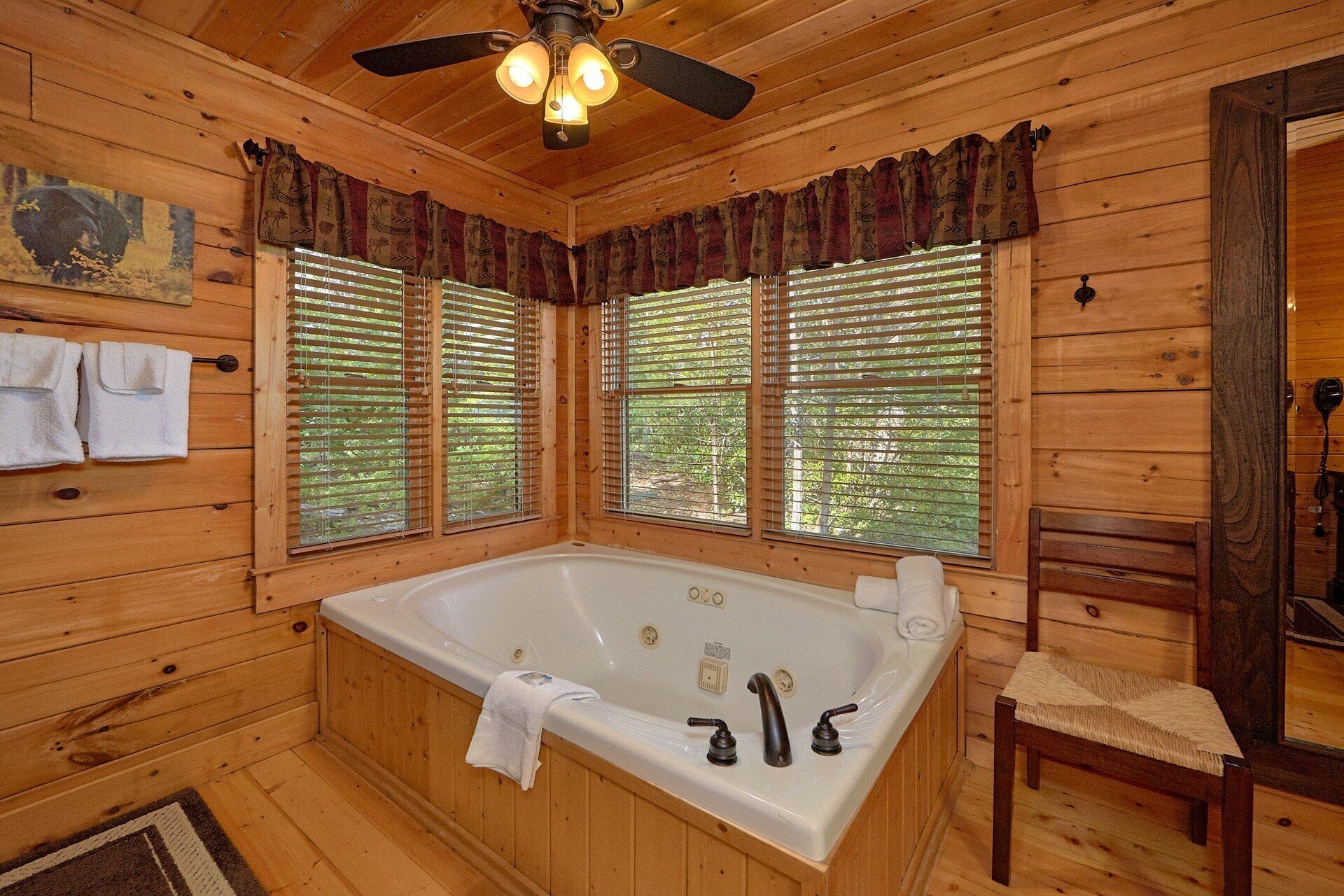 Ein Holzblock-Interieur mit einer großen Badewanne, Holzwänden und einem Deckenventilator.