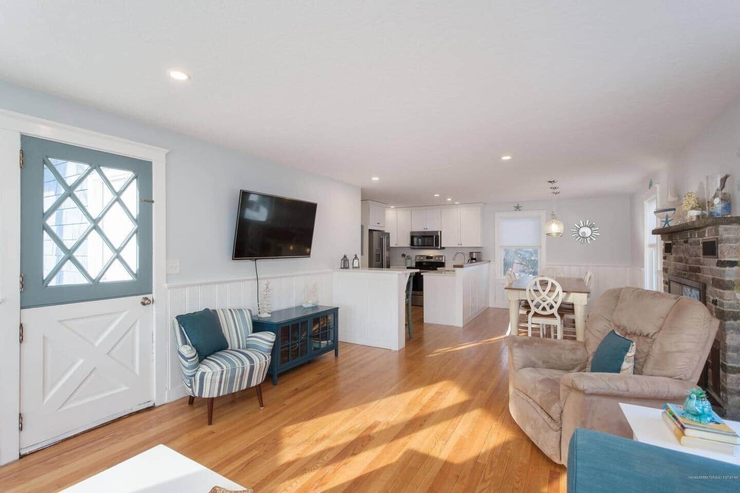 A spacious living area with a sofa, a dining table, and a kitchen in the background.