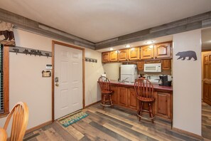 A kitchen with wooden cabinets, a microwave, a refrigerator, and a sink. - Appalachian Bear Den Cabin Rental (Pigeon Forge)