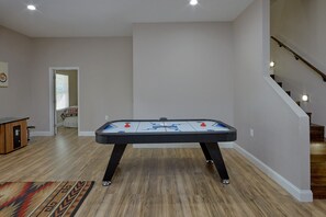 Um quarto com uma mesa de pebolim, um armário de madeira e uma escada.