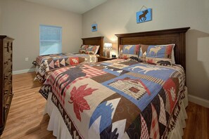 A bedroom with two beds, a dresser, and a window with blinds. - Bearfoot Bungalow | Hot Tub | Close to Dollywood | Free Attraction Tickets (Pigeon Forge)