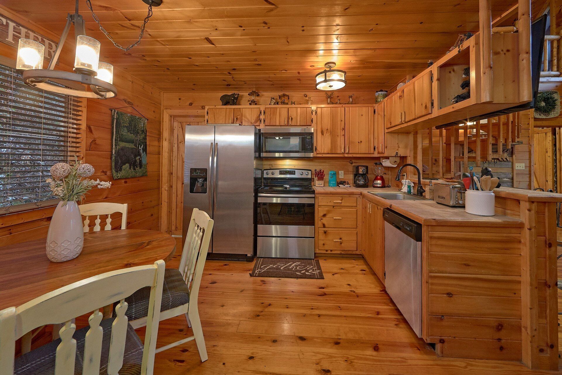 L’intérieur d’un chalet en bois comprend une cuisine équipée d’un réfrigérateur, d’un four, d ’un four à micro-ondes et d’armoires en bois.