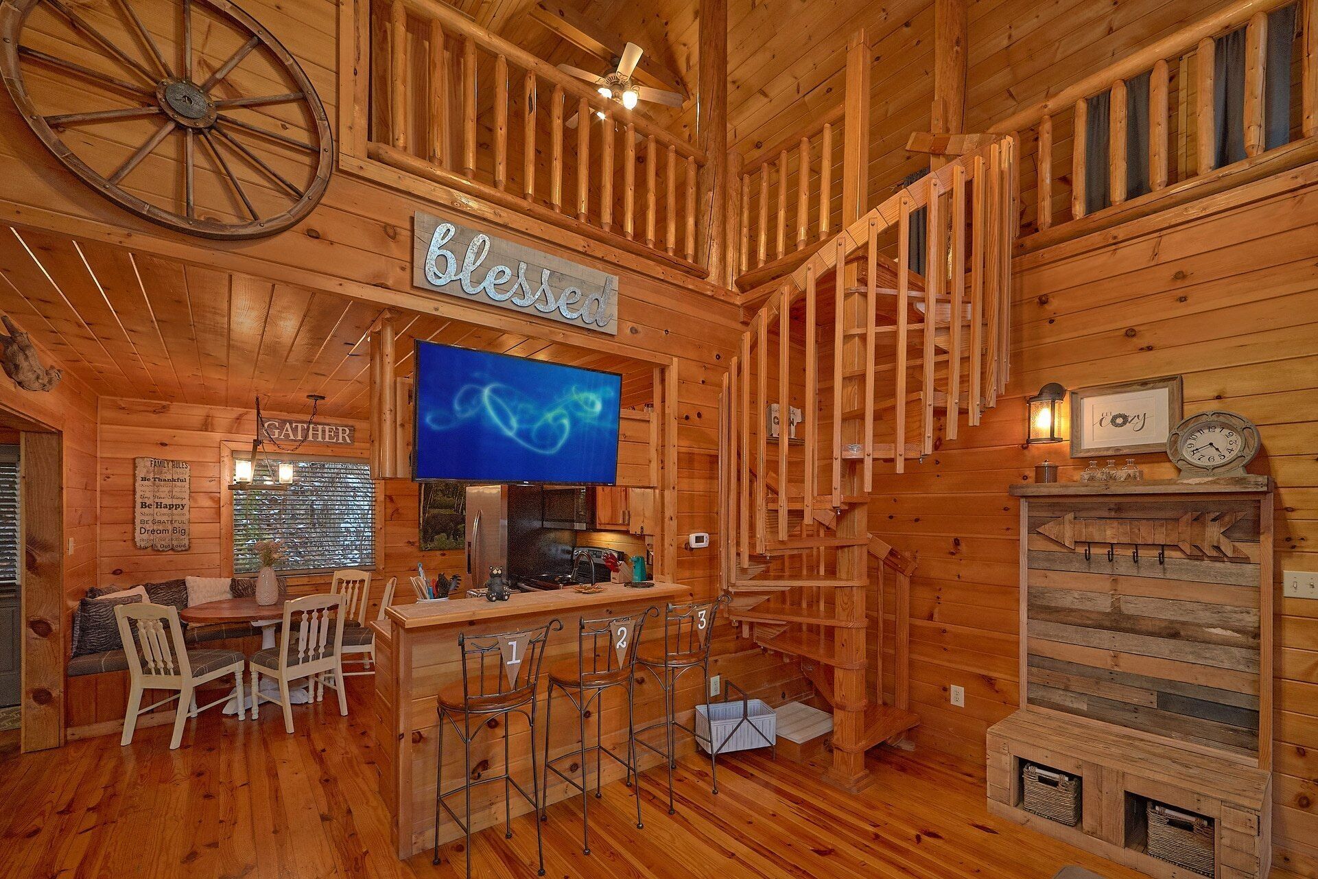 A rustic wooden interior with a bar area, a large wheel decoration, and a sign that reads 'Blessed.'