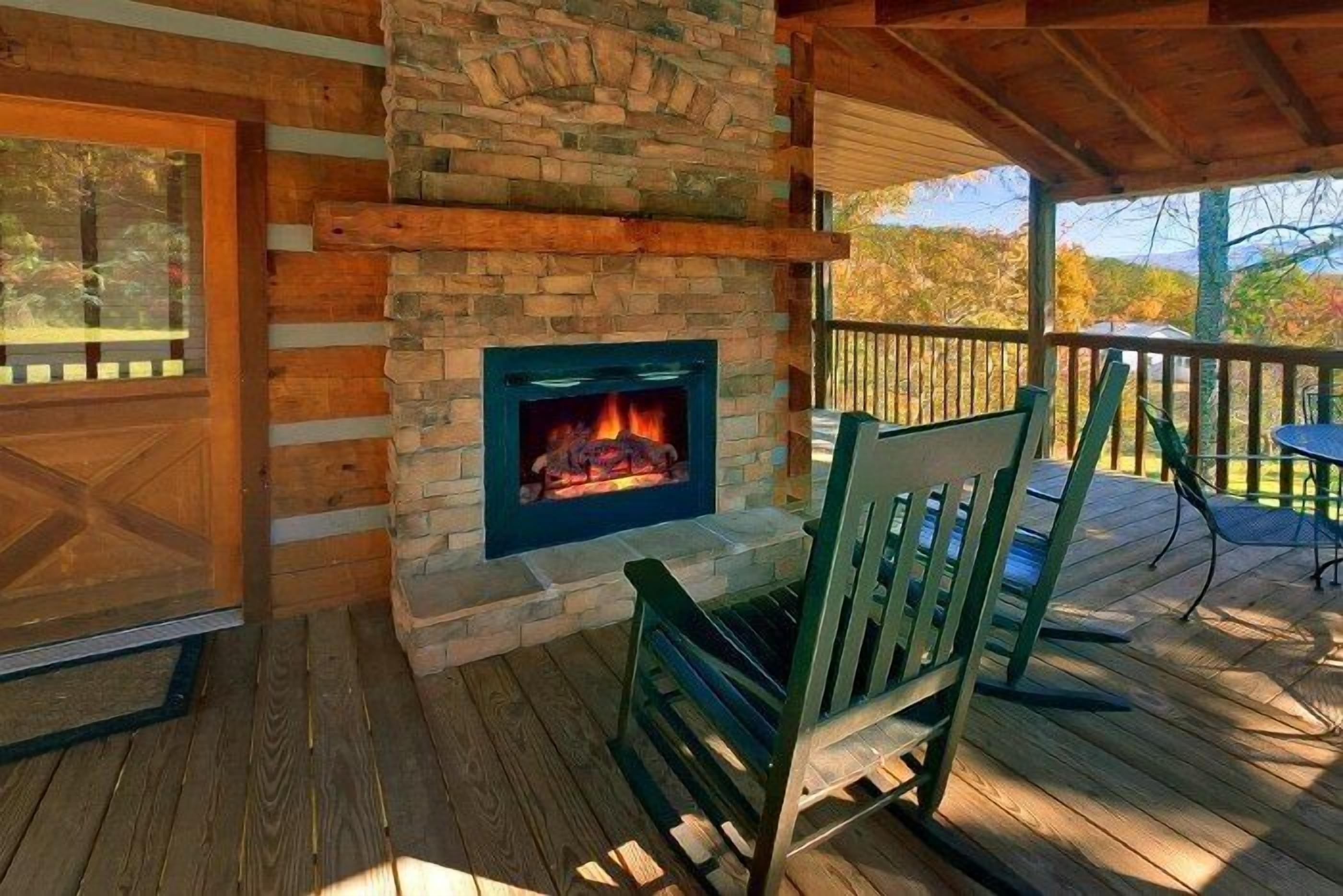 A wooden deck with a stone fireplace, a wooden door, and a green chair.