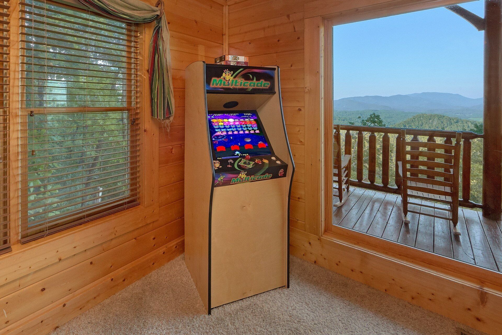 Une console de jeux vidéo dans une pièce en bois, avec vue sur les montagnes.