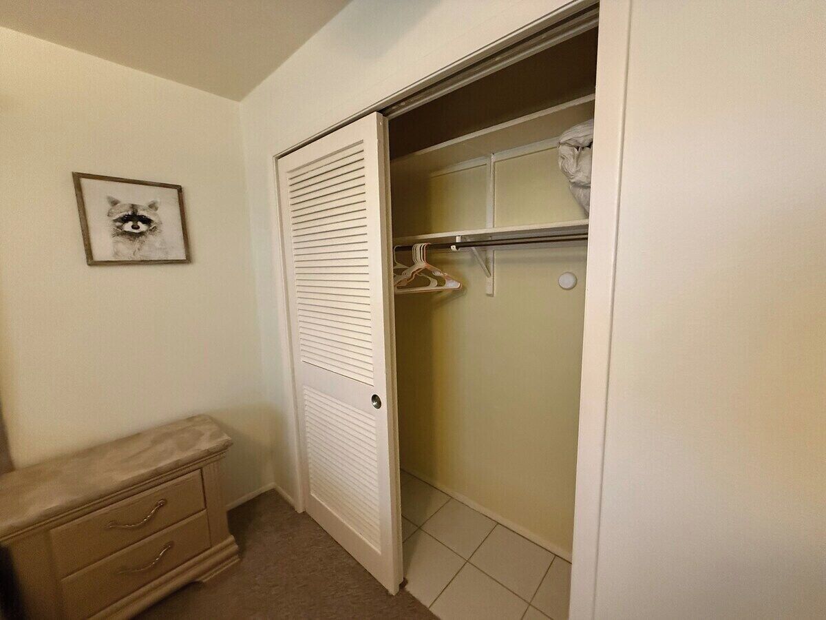 Un armario con espacio para colgar y una puerta de paneles listones.
