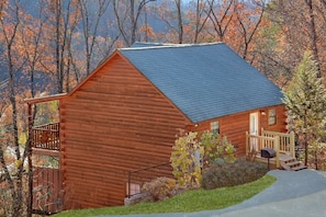 A log cabin with a porch, a small deck, and a front door. - Cheeky Chipmunk Getaway (Sevierville)
