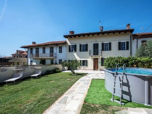 Ein zweistöckiges Haus mit Swimmingpool, einem Kiesweg und einer Rasenfläche.