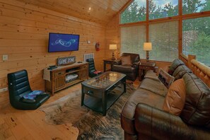 Un salon confortable avec un téléviseur, un canapé en cuir et une table basse.