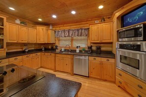 A kitchen with wooden cabinets, a dishwasher, a microwave, and an oven.