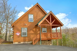 A log cabin with a porch and a stone foundation. - Heaven's Gift | Mtn Views, Hot Tub, Near Dollywood, Fireplace + Free Attraction Tickets (Pigeon Forge)