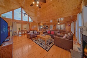 A spacious wooden cabin interior with a living room, kitchen, and dining area. - Knockin On Heaven's Door | Hot Tub, Arcade, Sleeps 12, King Suites + Free Attraction Tickets (Sevierville)