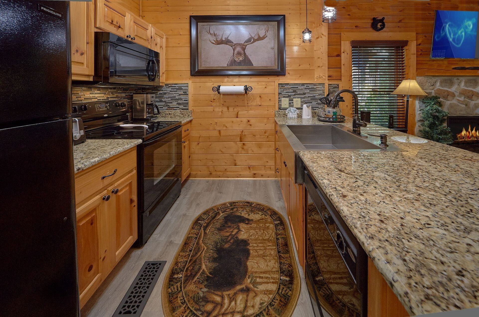 A kitchen with wooden cabinets, a granite countertop, a microwave, a stove, and a fireplace.
