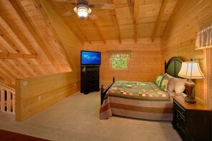 A bedroom with a bed, a television, a lamp, and a window. - Lucky Logs Lodge | Hot Tub, Near Dollywood, King Suites, Fireplace + Free Attraction Tickets (Pigeon Forge)