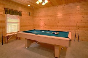A pool table in a room with wooden walls and a window with blinds. - Lucky Logs Lodge | Hot Tub, Near Dollywood, King Suites, Fireplace + Free Attraction Tickets (Pigeon Forge)