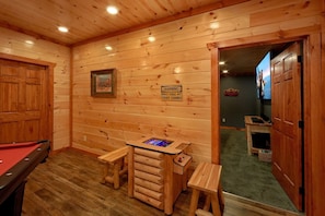 A wooden room with a pool table, a warning sign, and a television. - Majestic Splash Cabin Rental (Wears Valley)