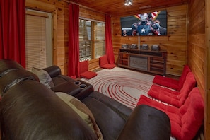 A cozy living room with leather sofas, a red rug, and a television mounted on the wall. - Major Oaks | Theater, Hot Tub, Game Room, Sleeps 12, King Suites + Free Attraction Tickets (Pigeon Forge)