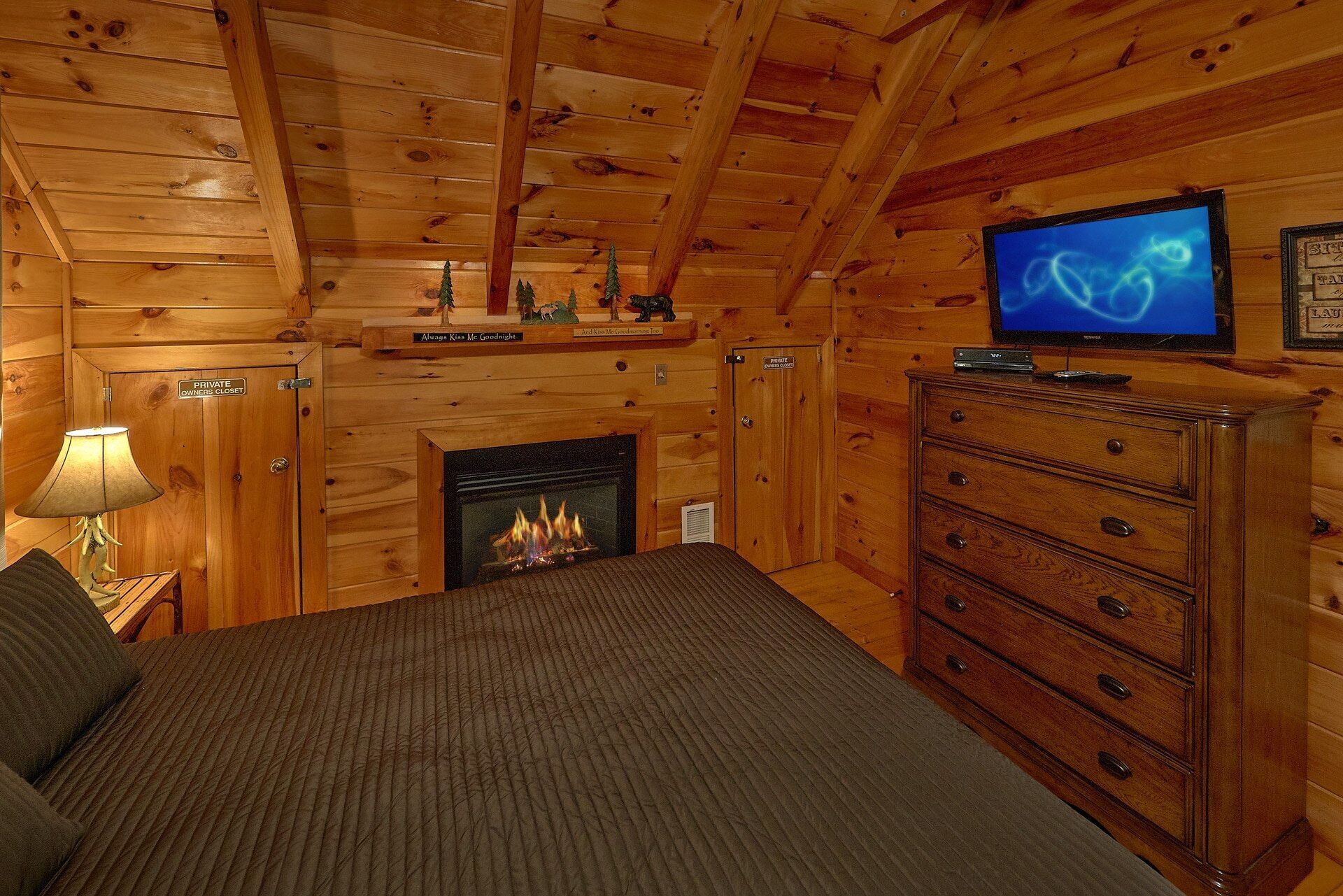 A cozy room with a fireplace, a television, and a private owner's closet.