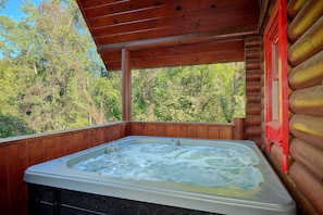A hot tub in a wooden cabin with a view of trees. - Merry Weather | Mtn Views, Hot Tub, Fireplace + Free Attraction Tickets (Sevierville)