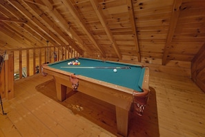 A pool table in a wooden room with a sloped ceiling. - Restin Easy | Hot Tub, Game Room, Fire Pit, Fireplace + Free Attraction Tickets (Sevierville)