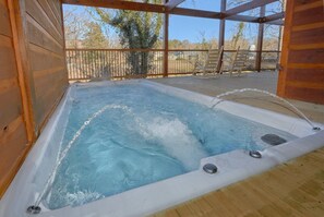 Ein Whirlpool mit Holzterrasse und Metallgeländer.