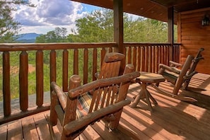 A wooden deck with rocking chairs and a view of a mountainous landscape. - Simply Irresistible | Theater, Hot Tub, Game Room, Pigeon Forge, Fireplace + Free Attraction Tickets (Pigeon Forge)