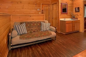 A wooden interior with a sofa and a wooden cabinet. - Simply Irresistible | Theater, Hot Tub, Game Room, Pigeon Forge, Fireplace + Free Attraction Tickets (Pigeon Forge)