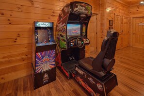 A wooden interior with two arcade gaming machines, one for 'The Fast and the Furious' and another for 'Crazy Taxi'. - Smoky Mountain Lodge | Sleeps 17, Theater, Hot Tub, Game Room, King Suites + Free Attraction Tickets (Pigeon Forge)
