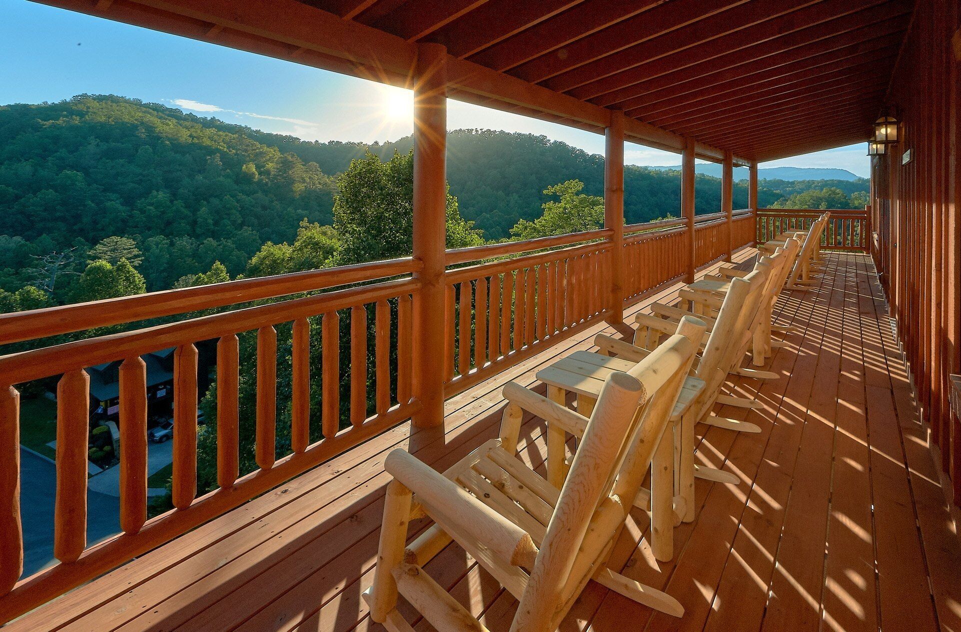 A wooden deck with a view of a forested mountain range.