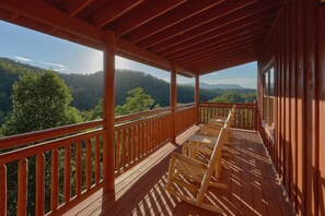 A wooden deck with a view of a forested mountain range. - Splashin On Majestic Mountain | Private Pool, Theater, Smoky Mtn Views + Free Attraction Tickets (Sevierville)