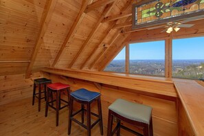 A wooden interior with a sloped ceiling, a stained glass window, and a view of the landscape. - The Overlook | Smoky Mtn Views, Hot Tub, Near Dollywood, Game Room + Free Attraction Tickets (Pigeon Forge)