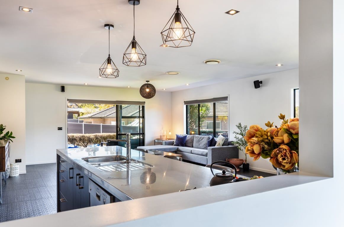 A modern kitchen with a central island, pendant lighting, and a view of the outdoors.