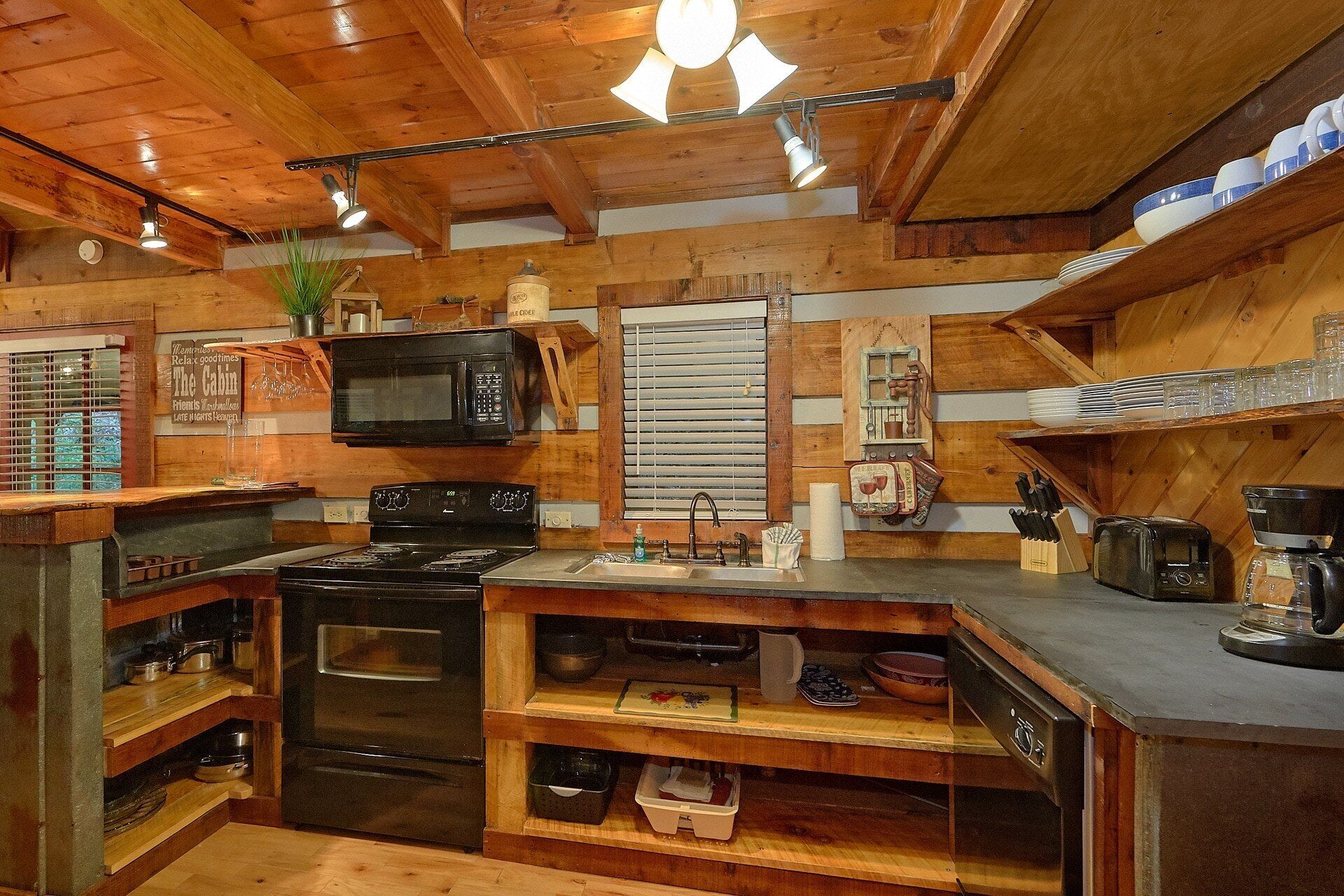 Una cucina con pareti in legno, un fornello, un forno a microonde e un lavello.