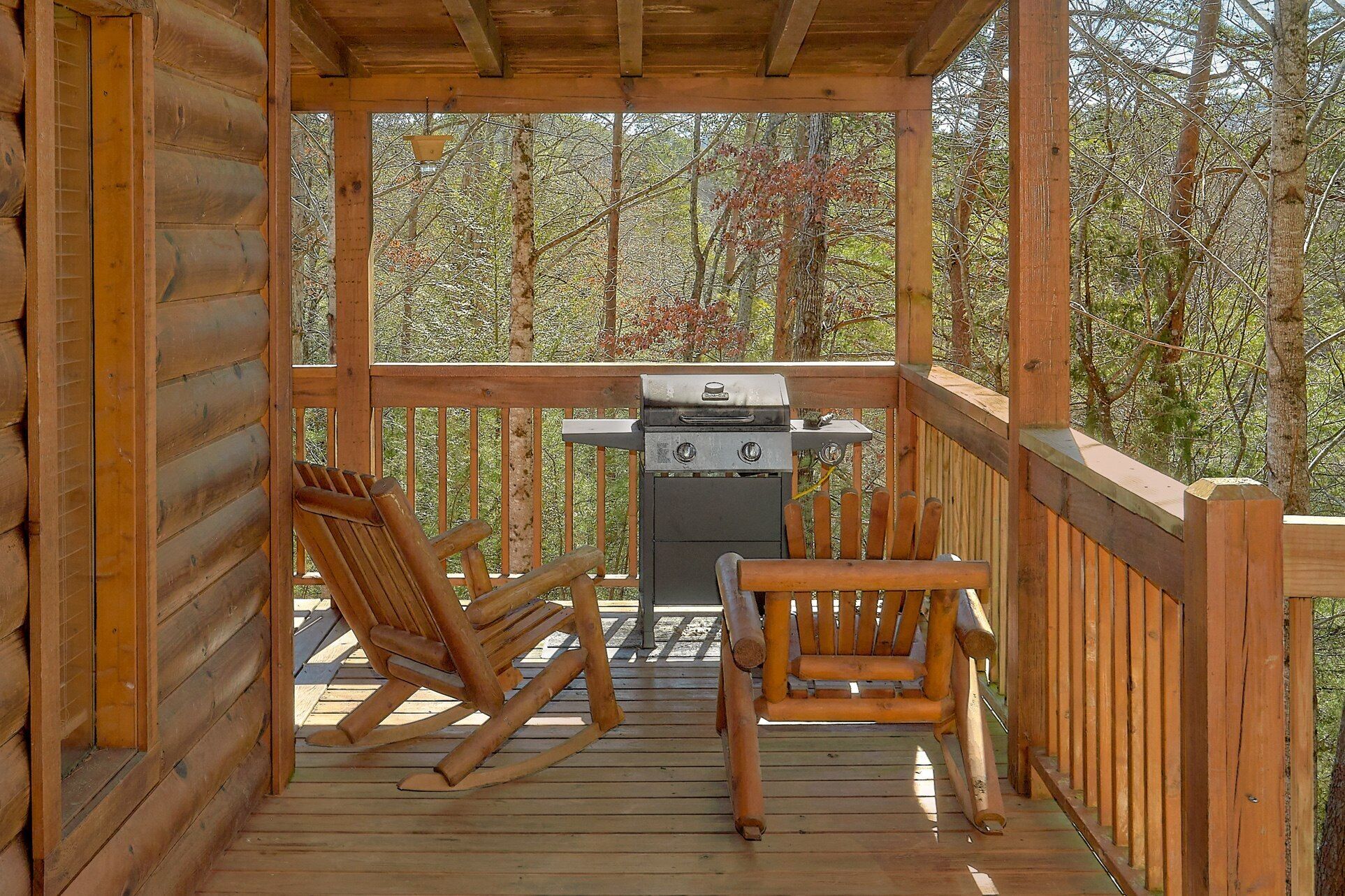 Eine Holzterrasse mit Grill und zwei Schaukelstühlen.