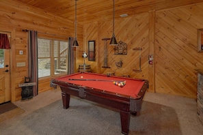 A pool table in a room with wooden walls and a carpeted floor. - Mountain Retreat | Theater, Mtn Views, Hot Tub, Fireplace + Free Attraction Tickets (Wears Valley)