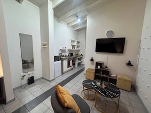 A modern living room with a sofa, a coffee table, and a TV mounted on the wall. - Experience Elevated Living in Dainfern's Panorama Suite (Johannesburg)