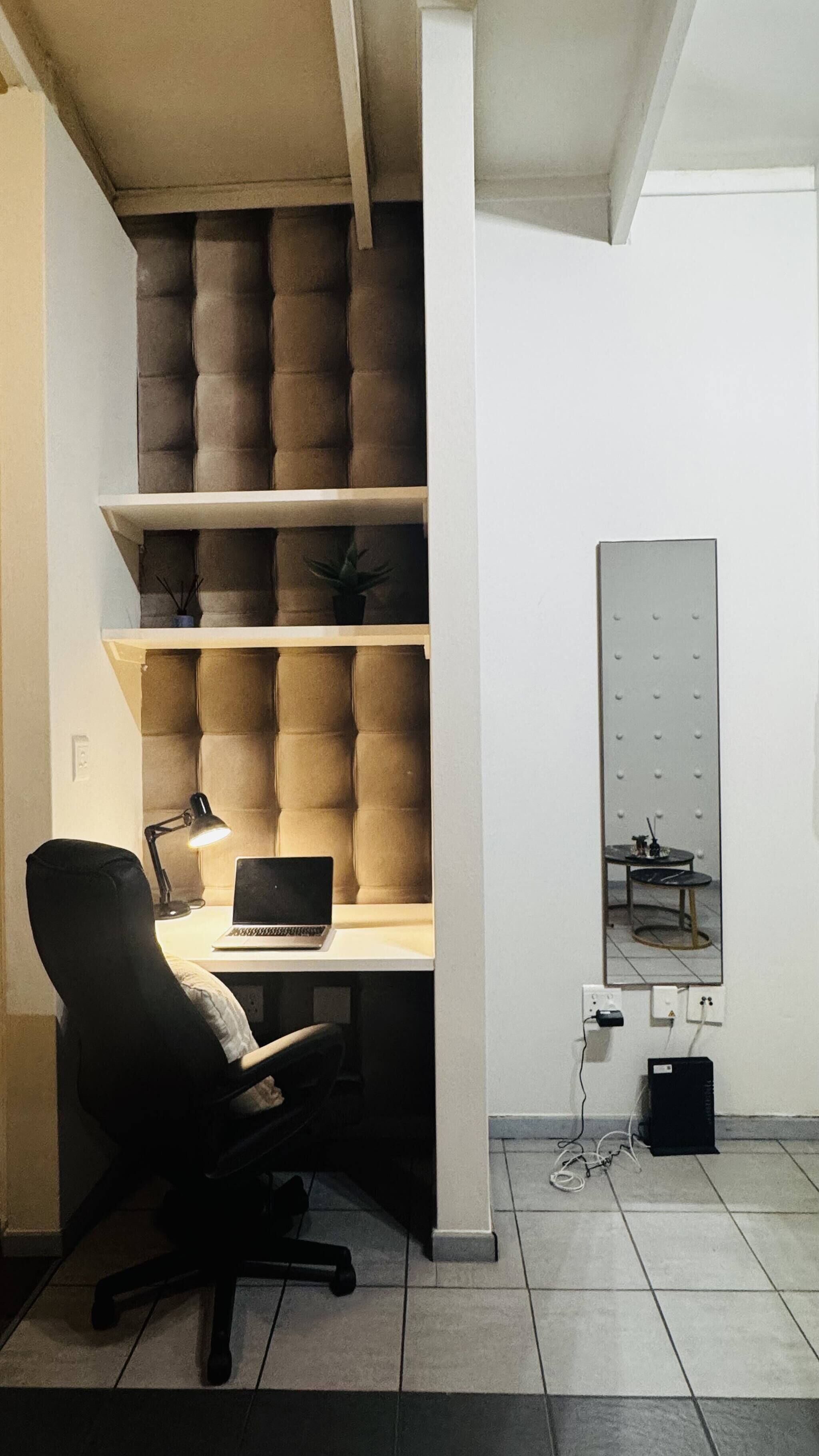 Un bureau à domicile équipé d’un bureau, d’une chaise, d’un ordinateur portable et d’étagères.
