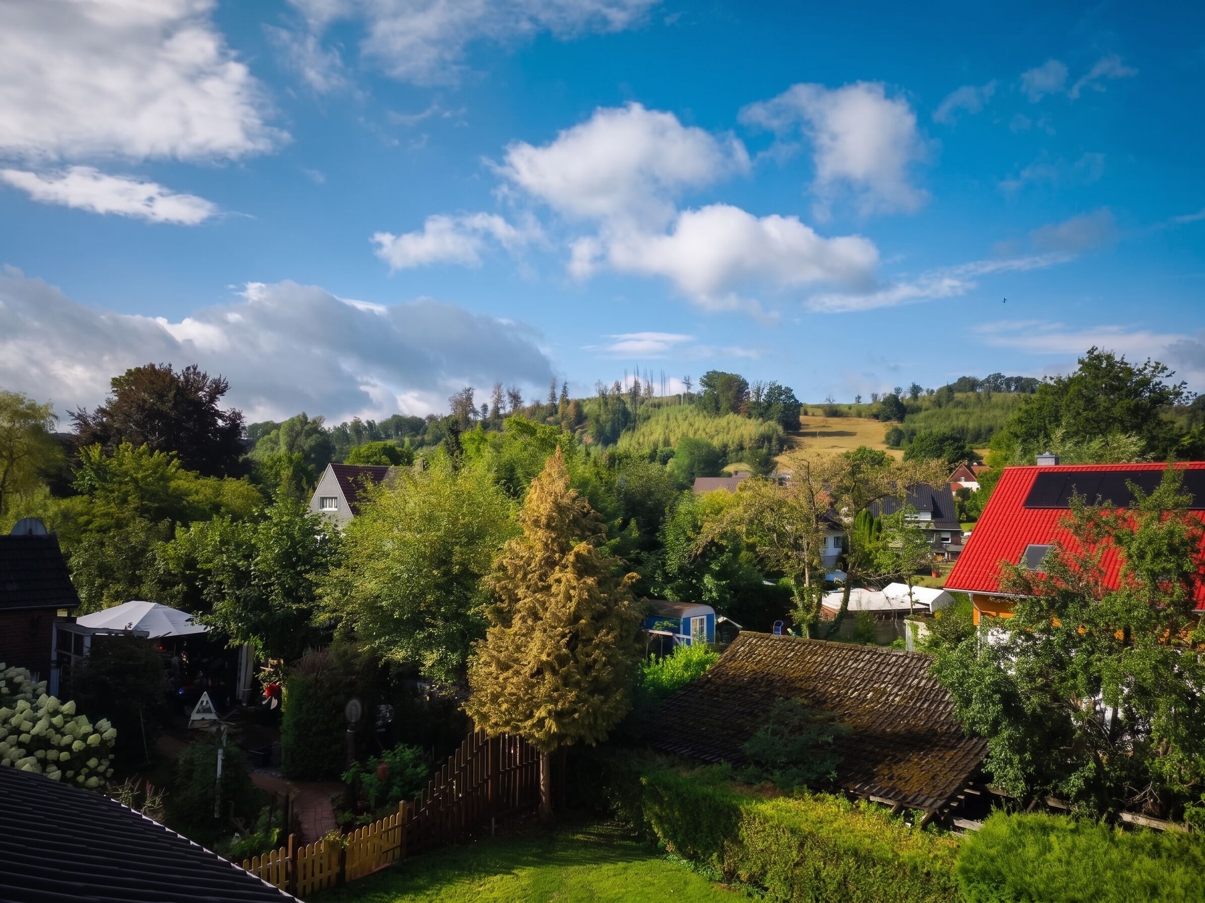 Un quartier résidentiel avec des maisons, une clôture en bois et un ciel dégagé.