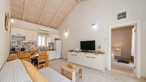 A compact living space with a kitchenette, a dining area, a sofa, and a television. - Nice home in Debeljak with private swimming pool, can be inside or outside (Debeljak)