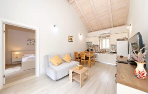 A compact living space with a sofa, a small table, a dining area with chairs, and a kitchen with cabinets and a refrigerator. - Nice home in Debeljak with private swimming pool, can be inside or outside (Debeljak)