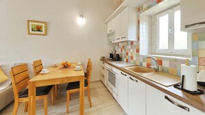 A compact kitchen with a dining table, chairs, a sink, and a window. - Nice home in Debeljak with private swimming pool, can be inside or outside (Debeljak)