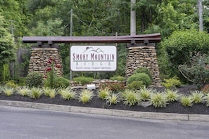 A sign for Smoky Mountain Ridge with a rustic design, surrounded by landscaped greenery. - A Smoky Mountain Dream | Mountain Views | Private Pool | Hot Tub (Wears Valley)