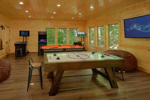 A room with a foosball table, a pool table, and a television screen. - A Smoky Mountain Dream | Mountain Views | Private Pool | Hot Tub (Wears Valley)