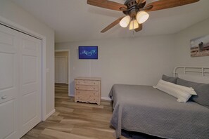 A bedroom with a bed, a dresser, a ceiling fan, and a television on the wall. - Mill Creek Cottage | Hot Tub, Pigeon Forge, Fireplace + Free Attraction Tickets (Pigeon Forge)