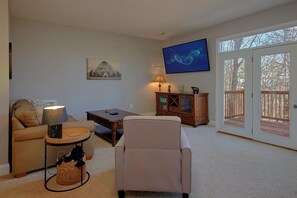 A living room with a sofa, a chair, a coffee table, a TV, and a cabinet. - Bear Necessities Vacation Home (Sevierville)