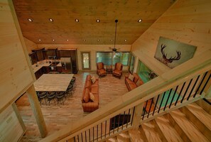 Ein Holzinnenraum mit Essbereich, Sofas und einem Deckenventilator.