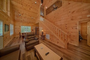 A wooden interior with a staircase, a sofa, a table, and a ceiling fan. - A Beary Good Life | Hot Tub | Close to Tanger Outlets | Minutes from the Parkway (Sevierville)