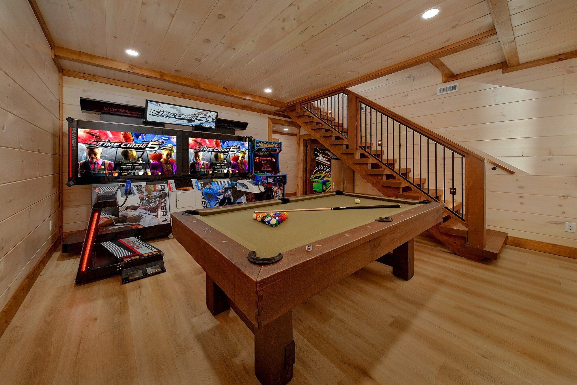 Une table de billard avec une queue de billard, un jeu de billes et un téléviseur diffusant un match.
