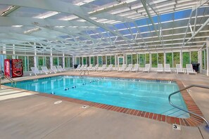 An indoor swimming pool with clear water, surrounded by lounge chairs and a Coca-Cola cooler. - Mountain View 3206 | Pigeon Forge, Resort Pool, Fireplace + Free Attraction Tickets (Pigeon Forge)
